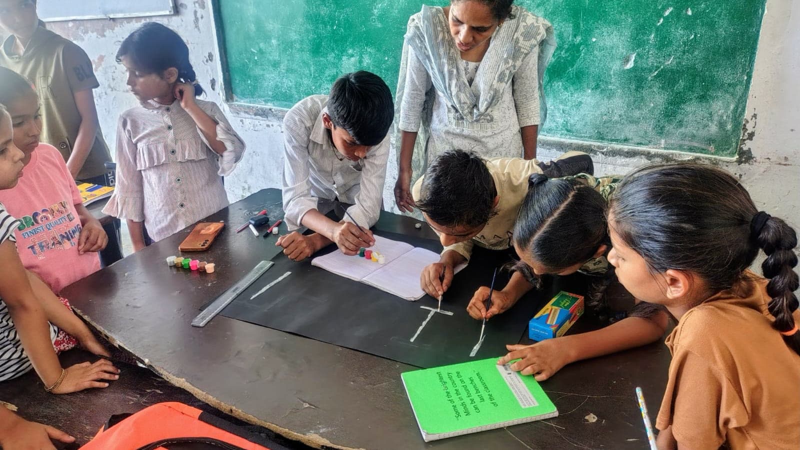 A Dreamwings mentor guiding students through a hands-on craft and measurement exercise