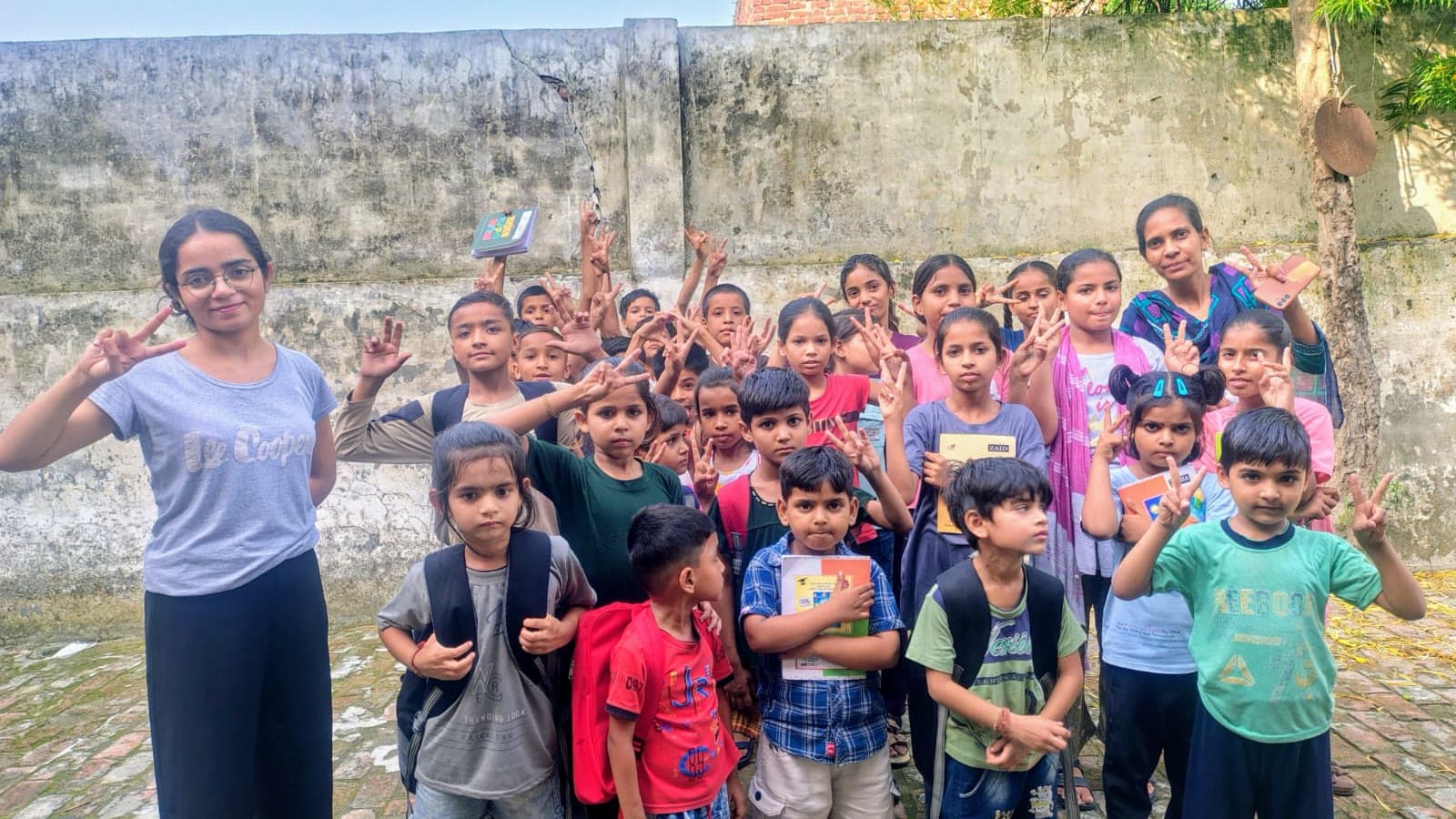 Children gathered outdoors with a Dreamwings volunteer before an activity session